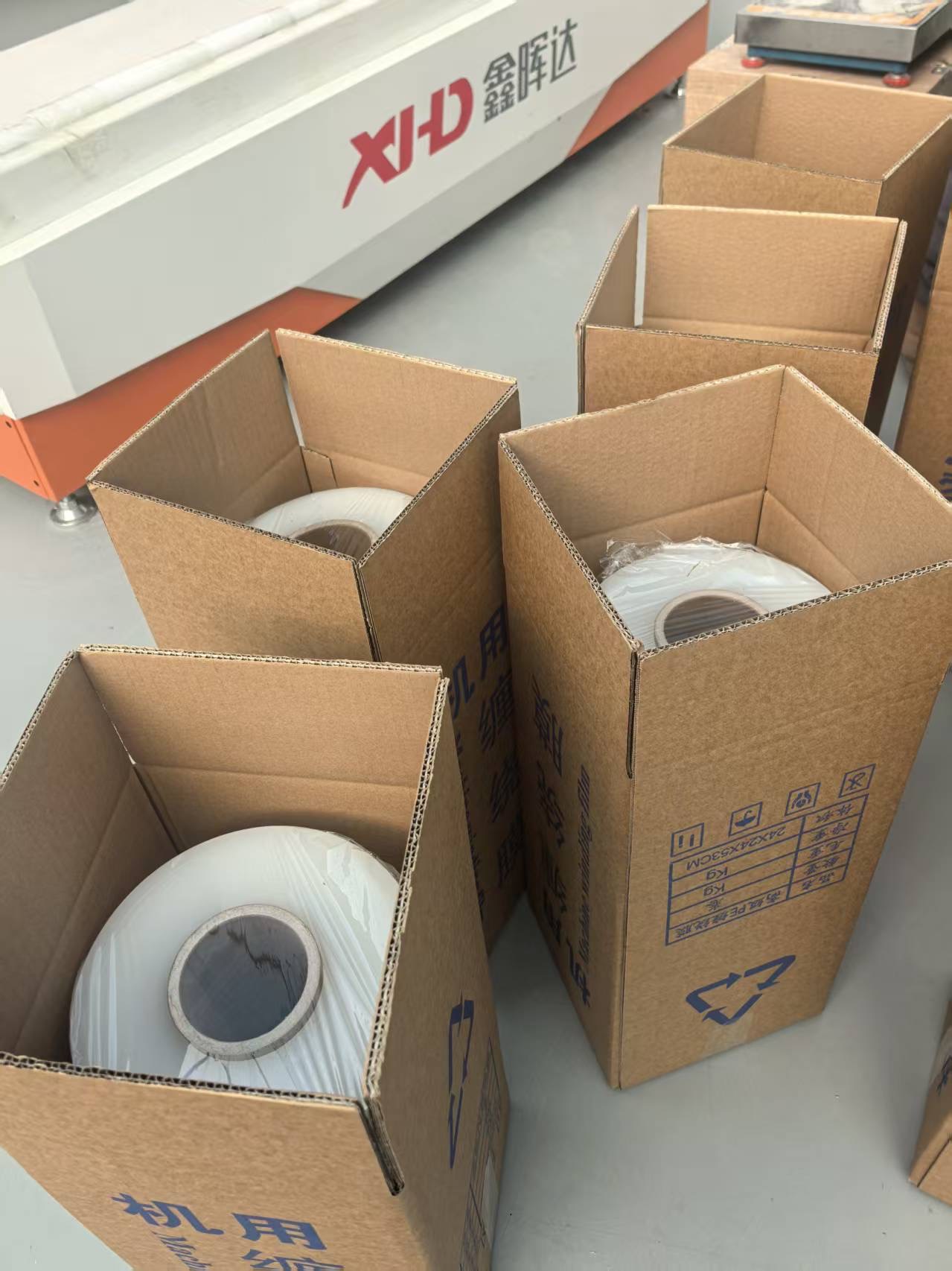 整齐码放的工业包装材料,包括缠绕膜、胶带和打包带卷